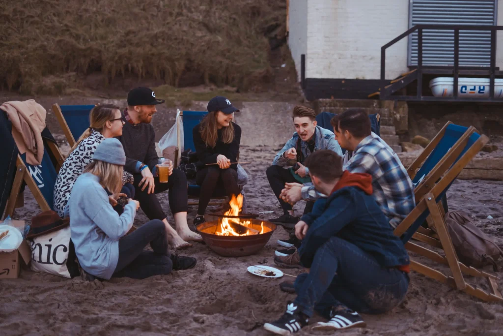 Friends sitting around fire sharing travel stories