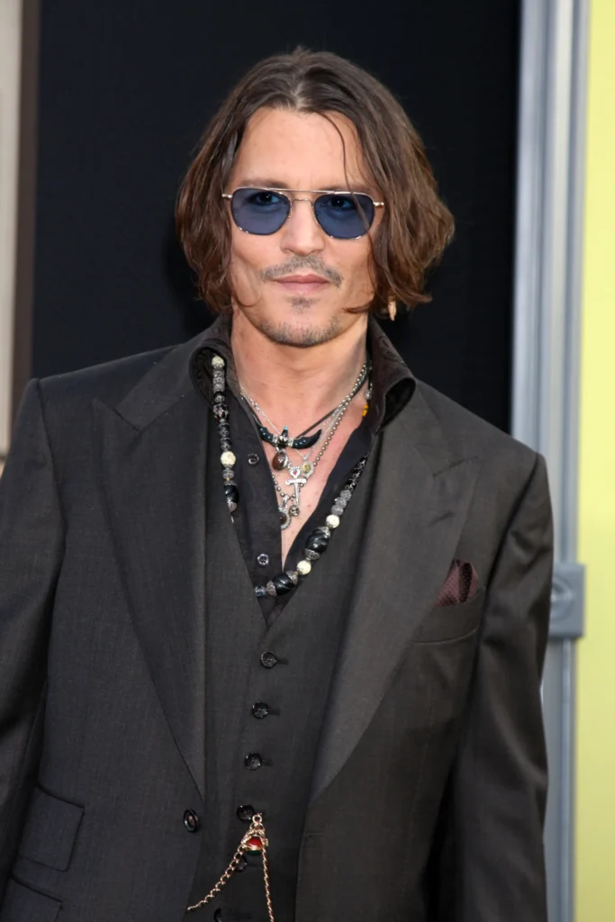 Johnny Depp with blue sun glasses on and a badass look.