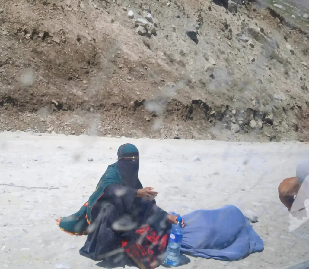 A female beggar sitting on the road in Afghanistan.